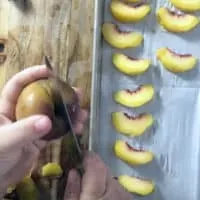 using a paring knife to cut a peach in half, peach slices on the side