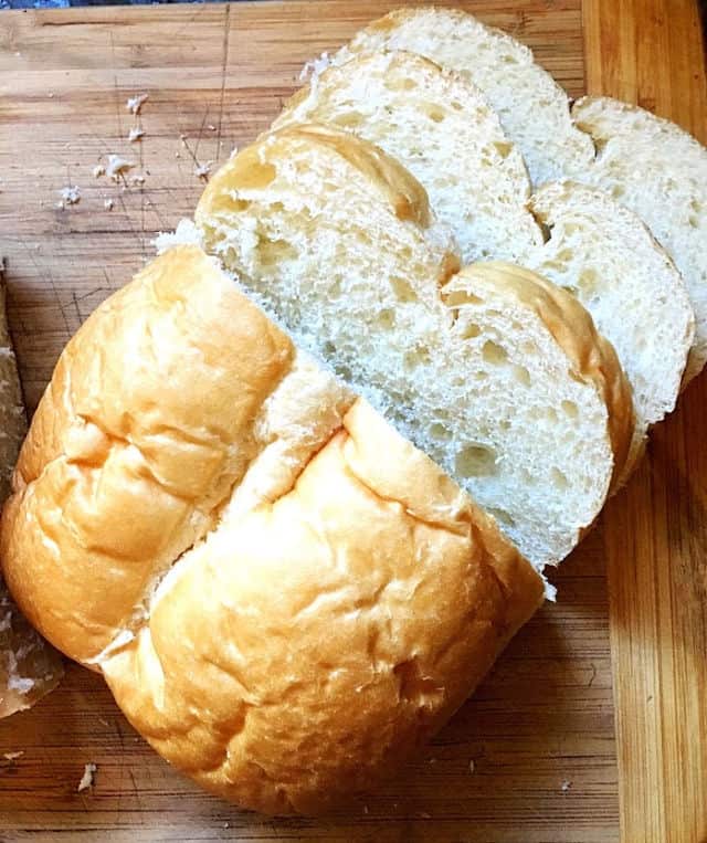homemade loaf of bread on cutting board with slices