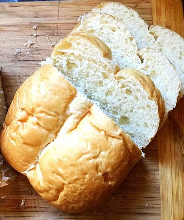 homemade loaf of bread on cutting board with slices