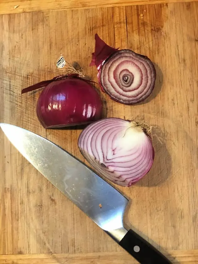 purple onion on a cutting board with knife