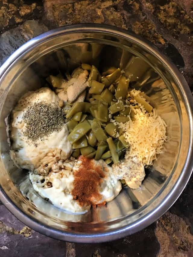 all of the ingredients for green bean casserole in silver bowl