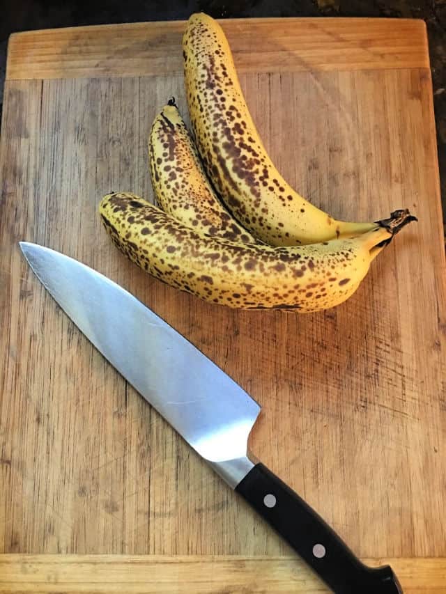 bananas on cutting board with a knife