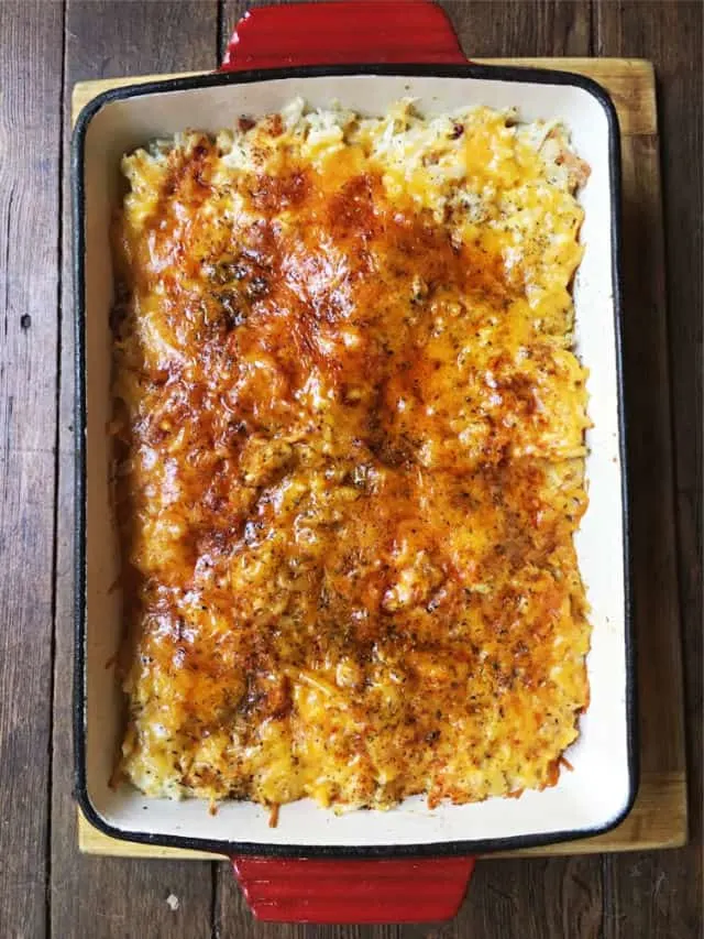 a baked cheesy top of hashbrown casserole in red dish