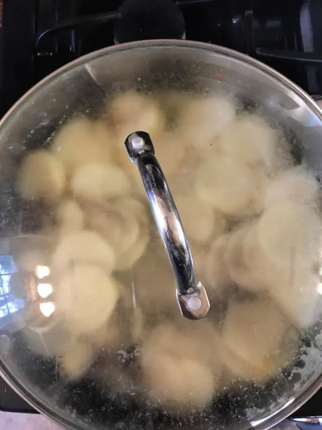 sliced potatoes in pan with lid on