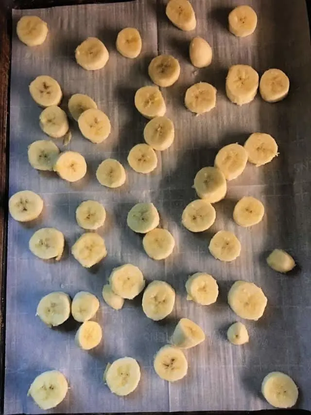 Banana disks on a baking sheet with parchment paper