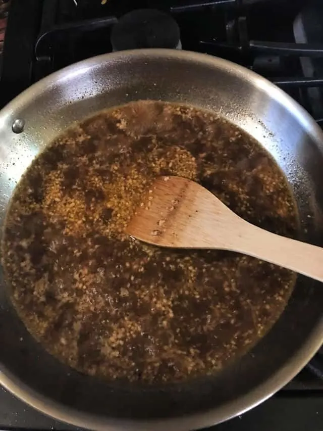 heating the sauce ingredients in pan with wooden spoon