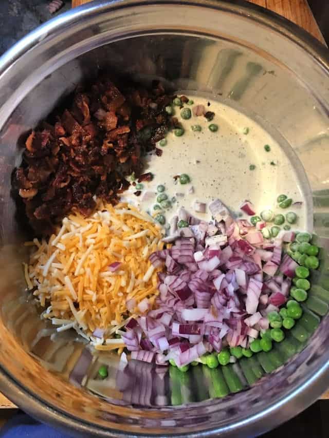 peas, onion, cheese, bacon and sauce in a bowl