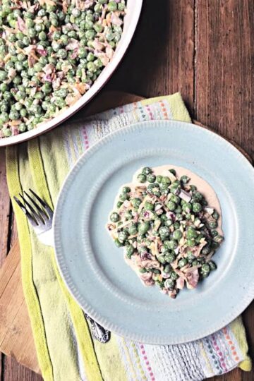 pea salad on a blue plate with fork and green towel