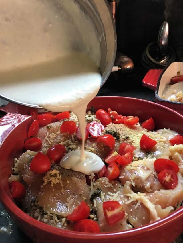 cream sauce being poured over caprese chicken