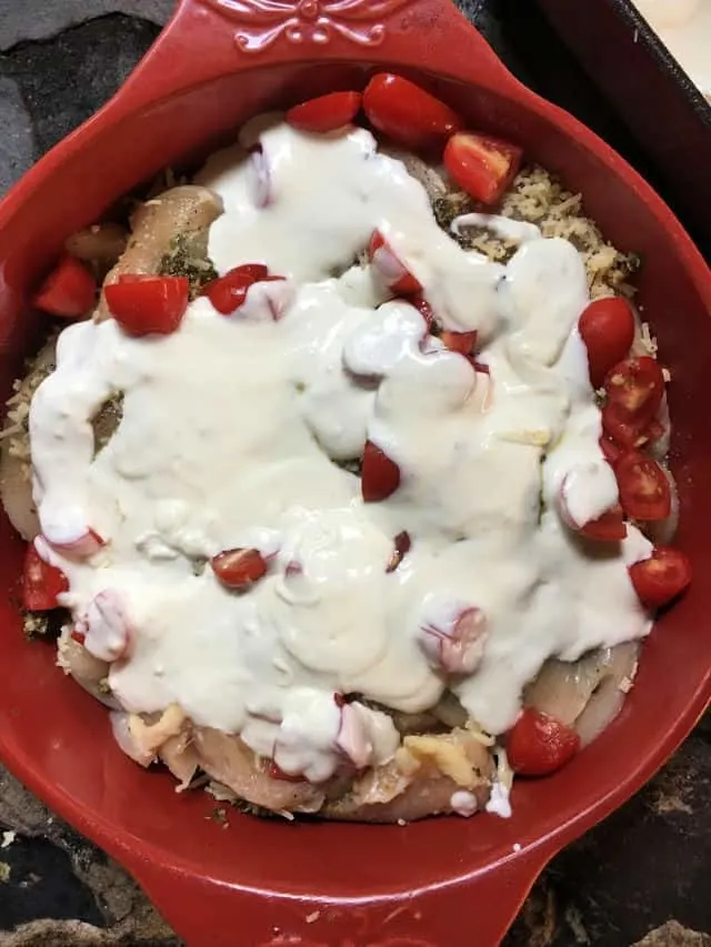 caprese chicken in red baking dish ready for oven