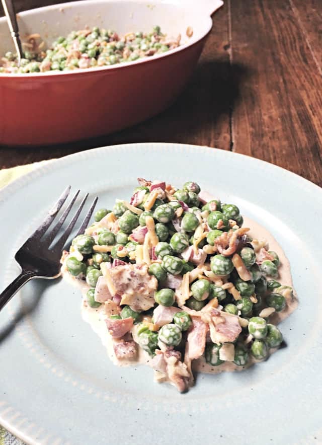 english pea salad on a blue bowl with fork