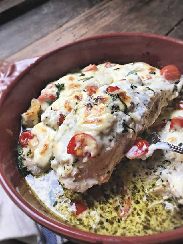 piece of chicken being lifted from baking dish