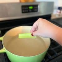 celery being dropped into pot of water
