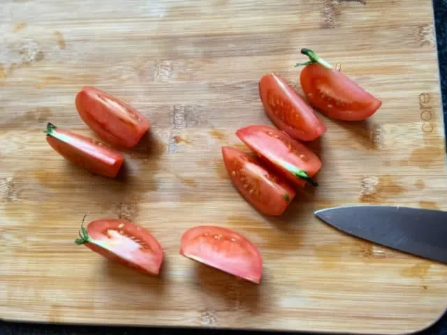 Tomato slices on cutting board with knife