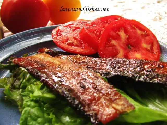 strips of pig candy bacon on lettuce with tomato