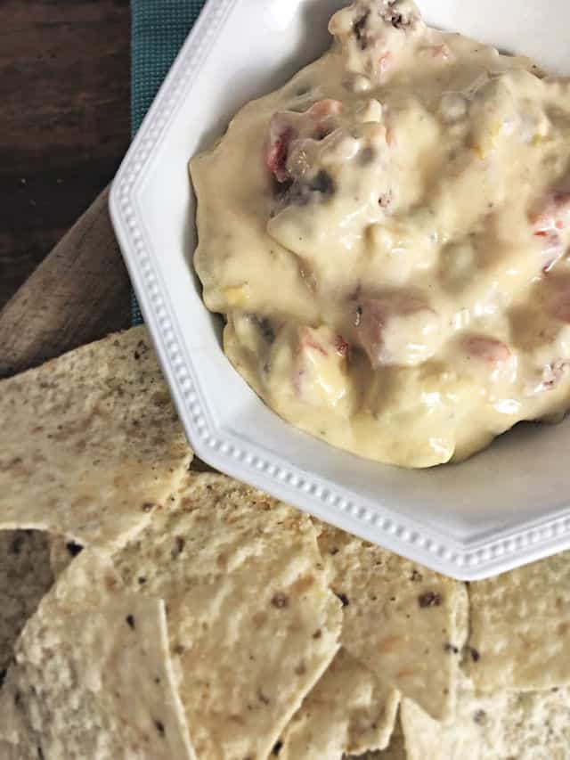 white bowl of cheese dip with chips