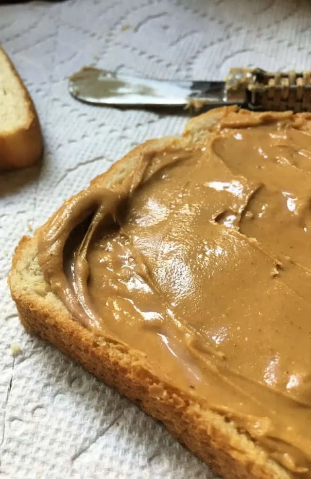 peanut butter puddled up on a slice of bread