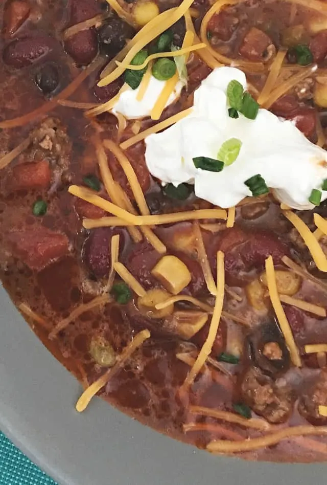 dollop of sour cream on top of close up of 8 can taco soup