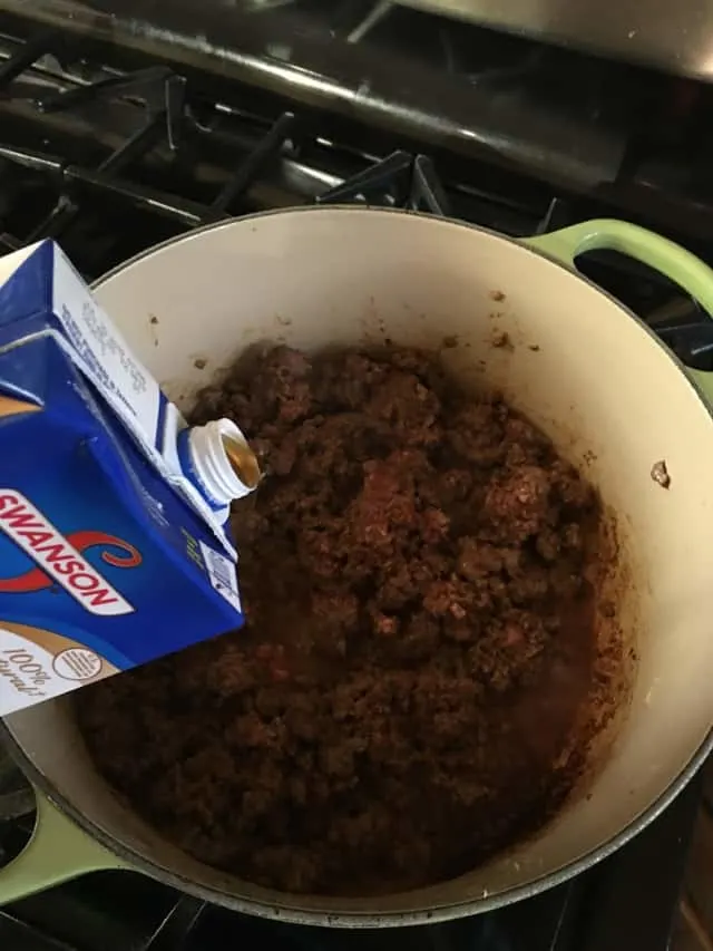 adding stock or broth to ground beef in stock pot