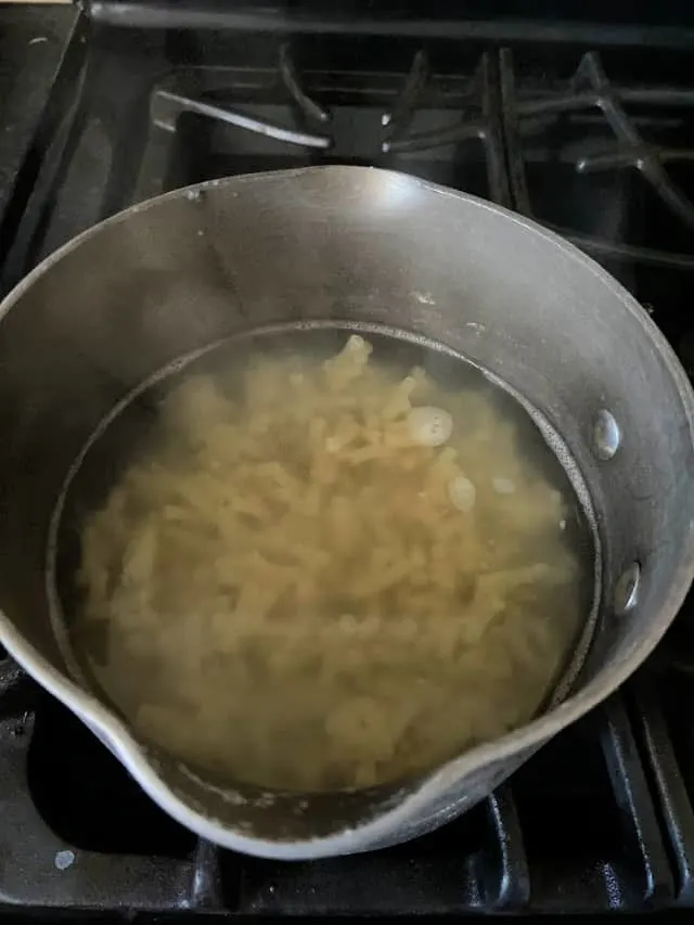 saucepan of macaroni noodles in water on stovetop