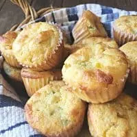 close up of mexican corn muffins in a basket with blue and white towel