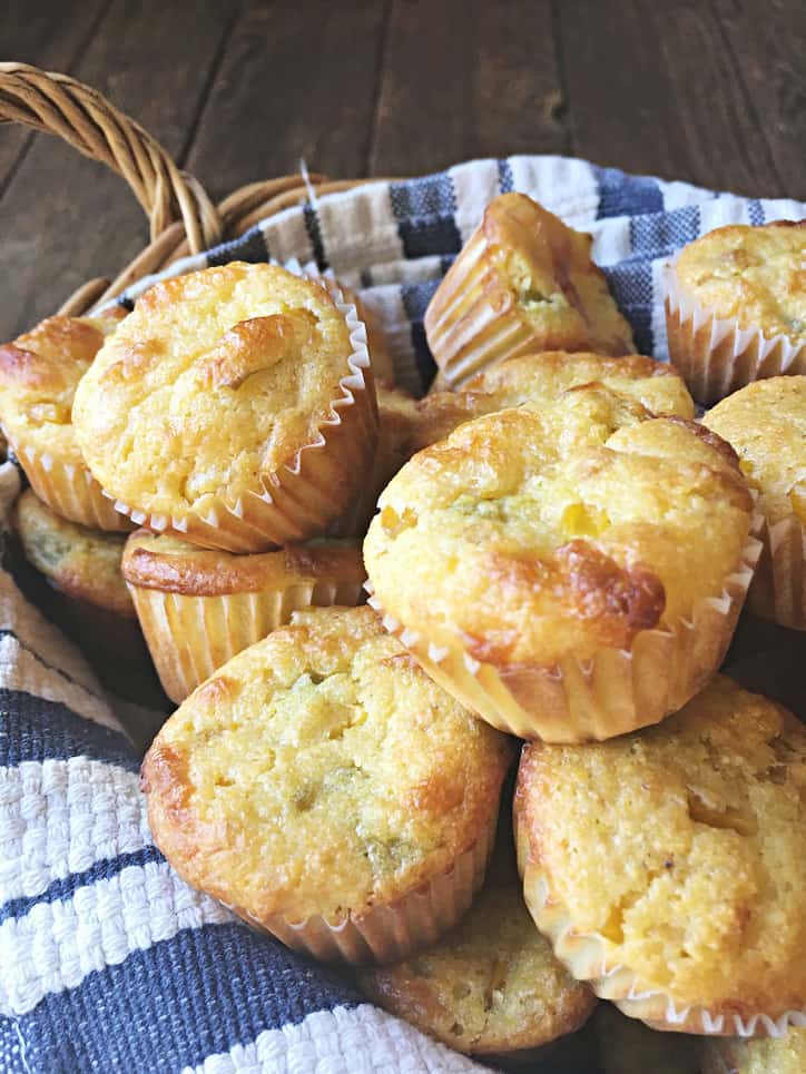 close up of mexican corn muffins in a basket with blue and white towel