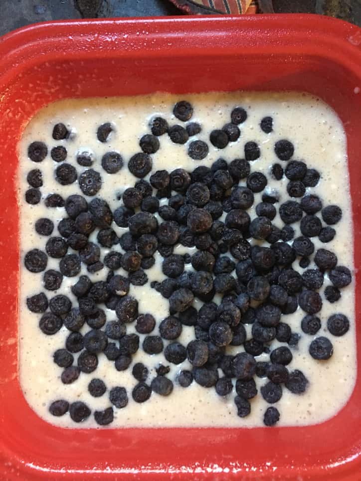 Blueberries in batter in a red baking dish