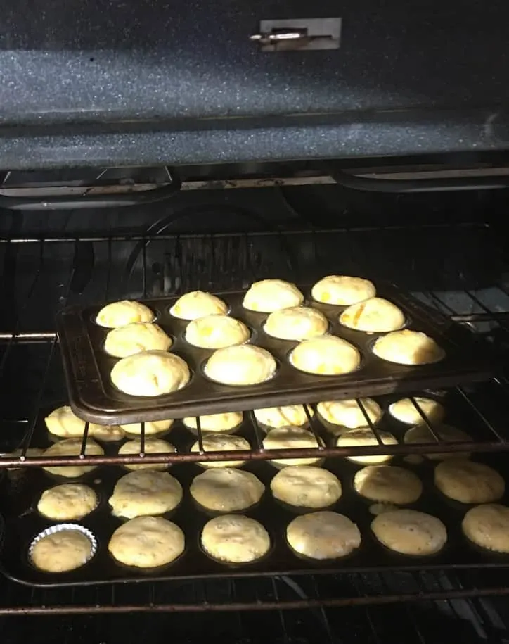two mini muffin pans of corn bread muffins in oven 