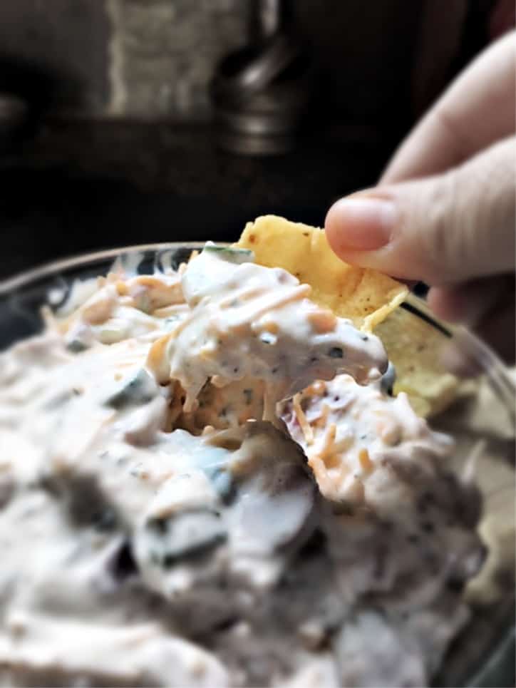 loaded ranch dip on a chip scooped from bowl