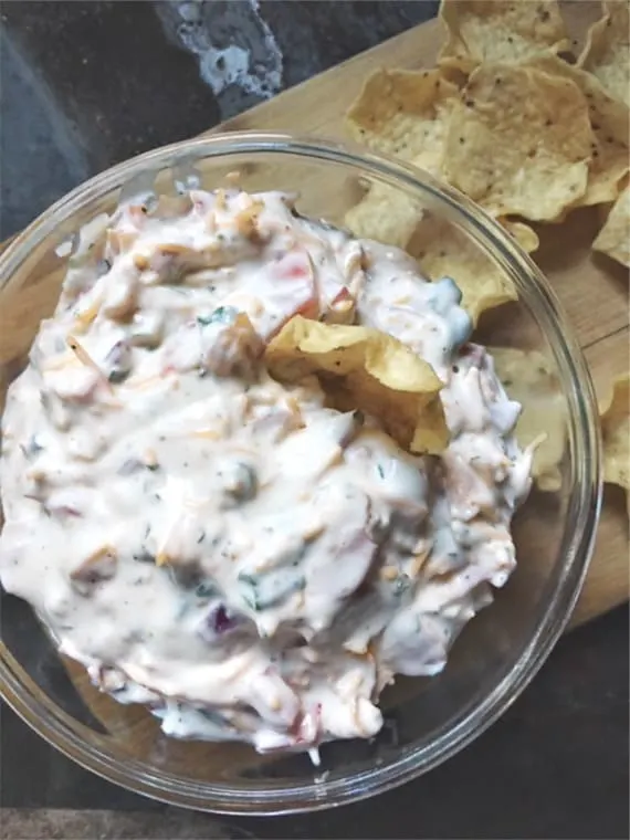 close up of glass bowl of dip and chips