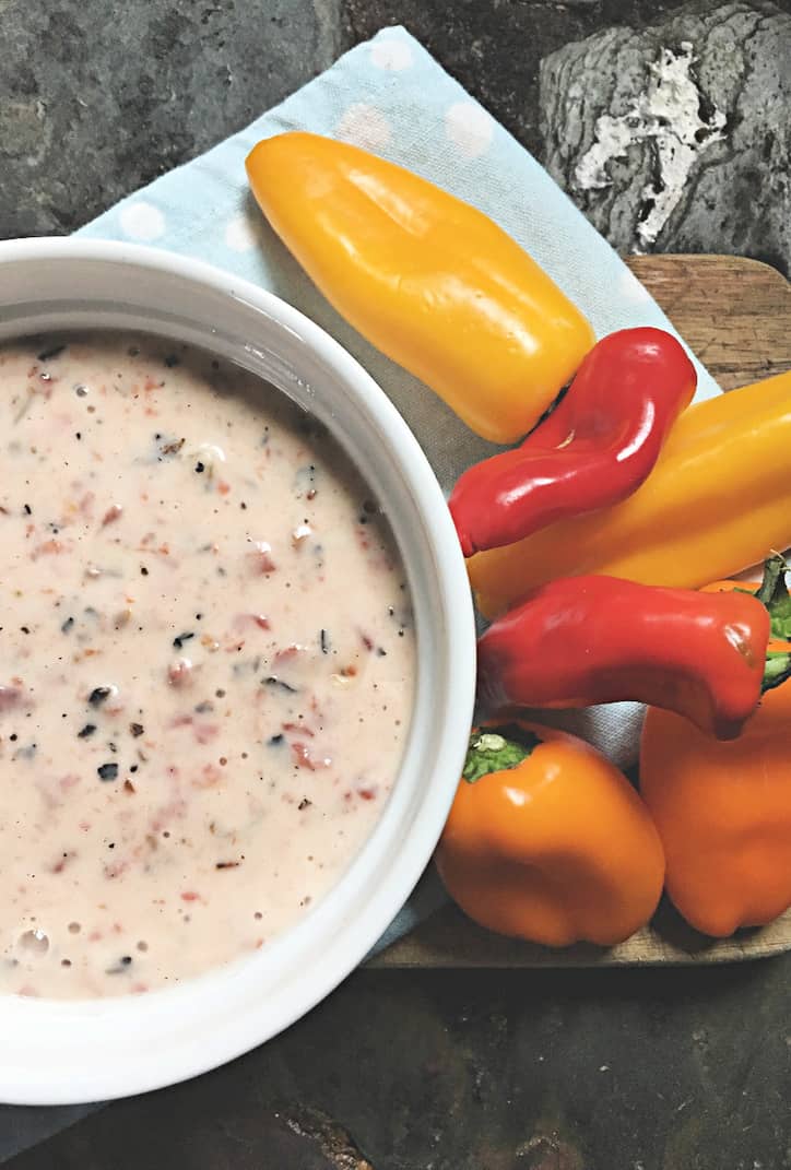 bowl of cheese dip and peppers on blue towel