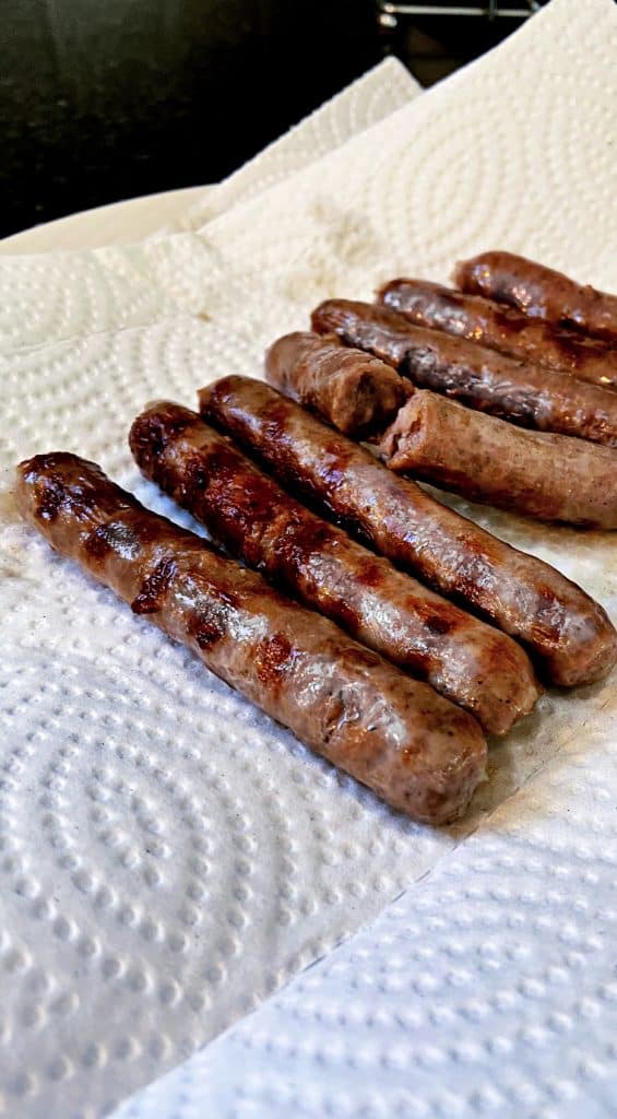 browned sausage links with grill marks on paper towel.
