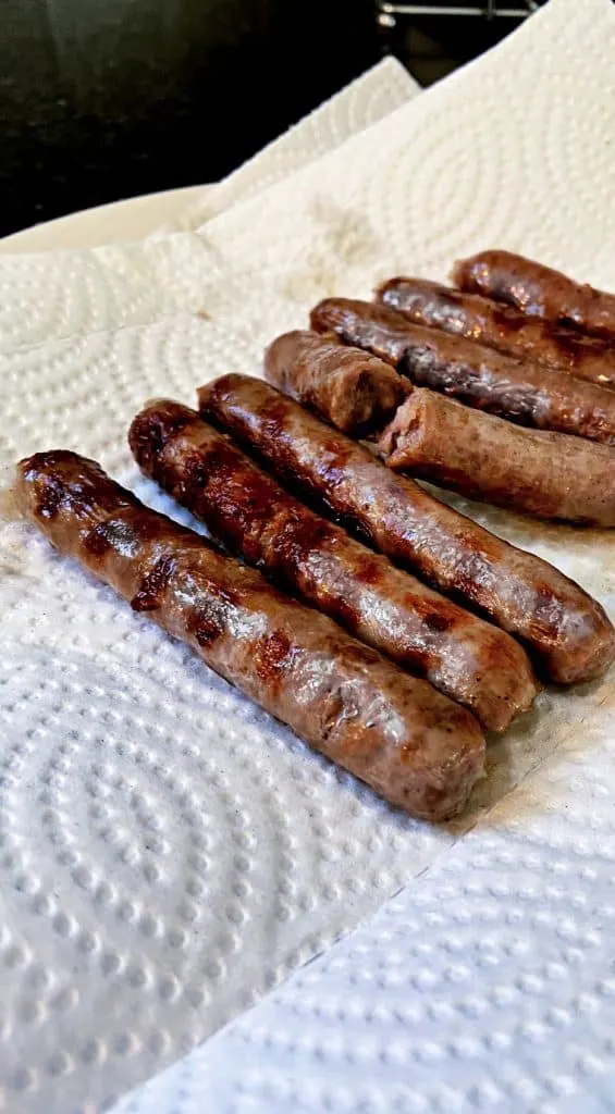 browned sausage links with grill marks on paper towel.