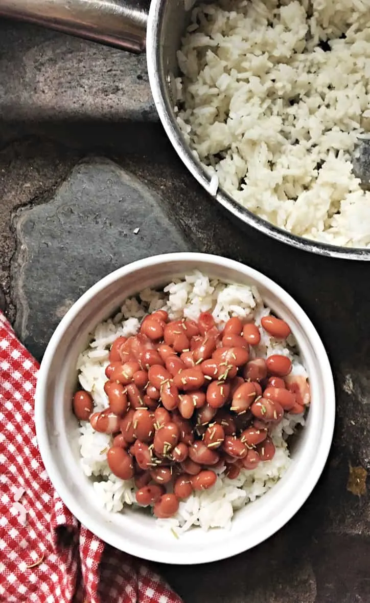 small white bowl of beans and rice with gingham towel