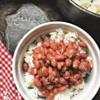 bowl of popeyes red beans and rice with large pot of rice