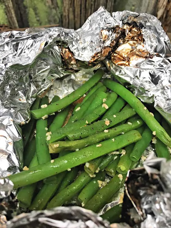 foil package opened to reveal green beans with garlic