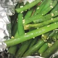fresh green beans roasted in aluminum foil on the grill