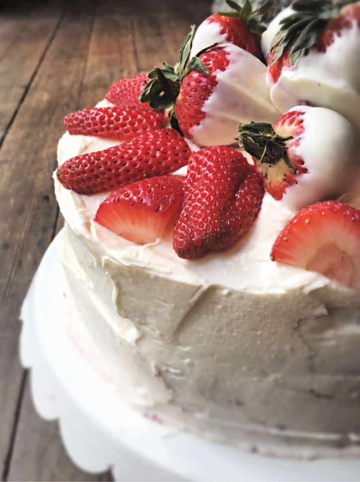 close up of white dessert icing with red fruit on top