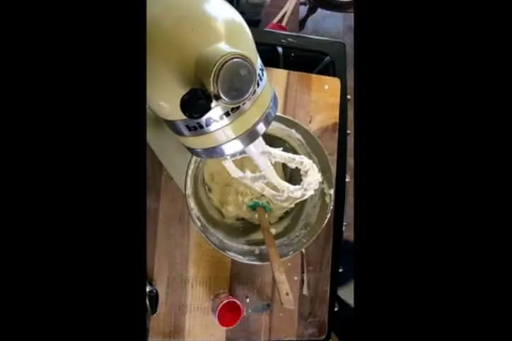 mixer with bowl of icing and cutting board