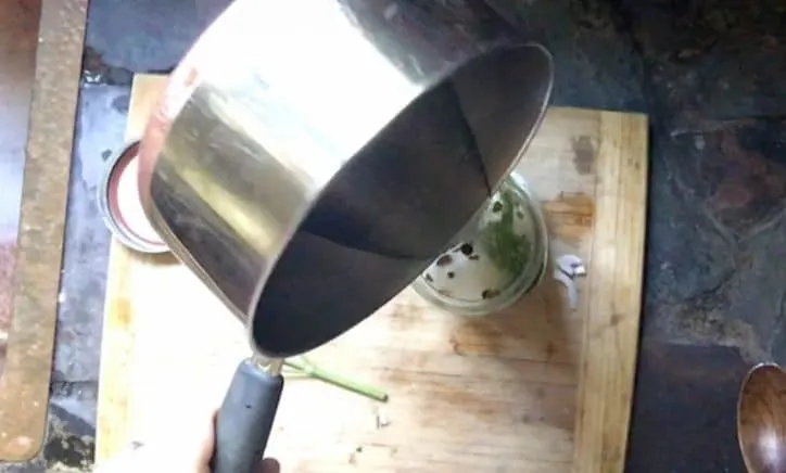 saucepan adding vinegar to jar