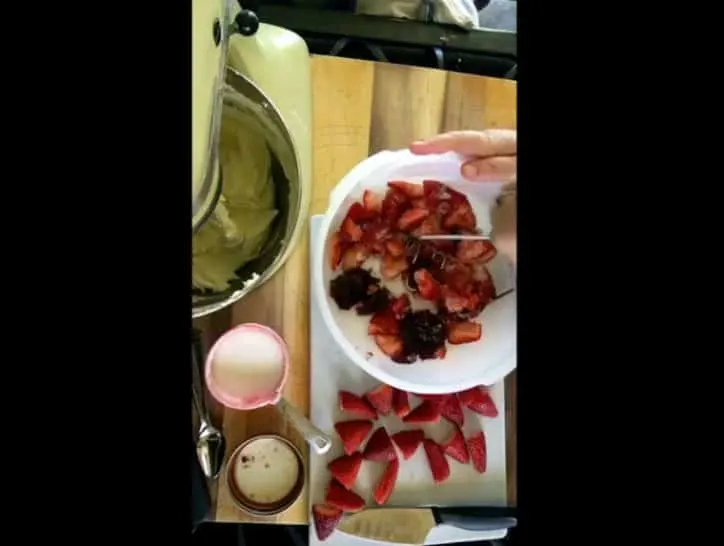 white bowl of berries with masher and mixer