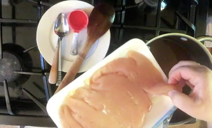 hand putting chicken into a tea brine