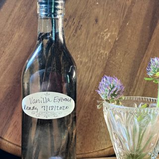 bottle of fresh made vanilla extract and flowers