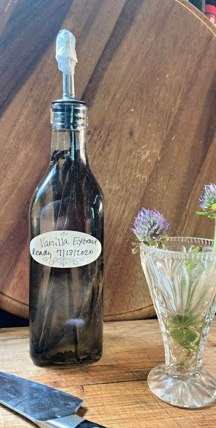 bottle of fresh made vanilla extract and flowers