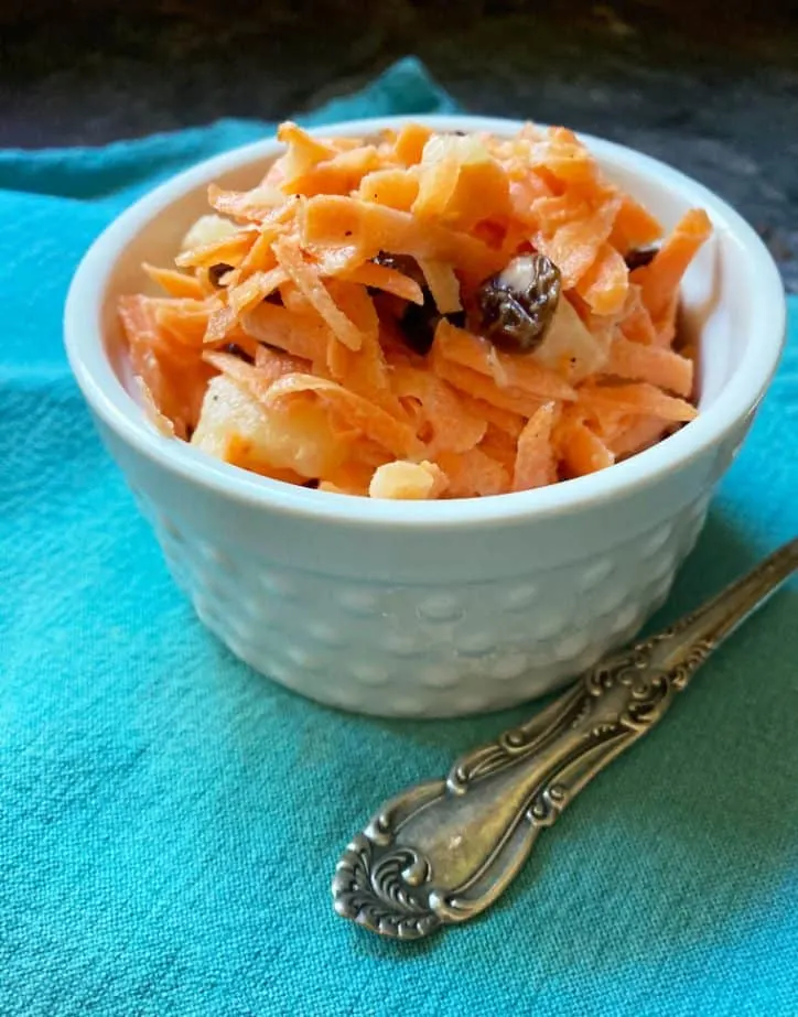 white dimpled bowl of salad on blue towel