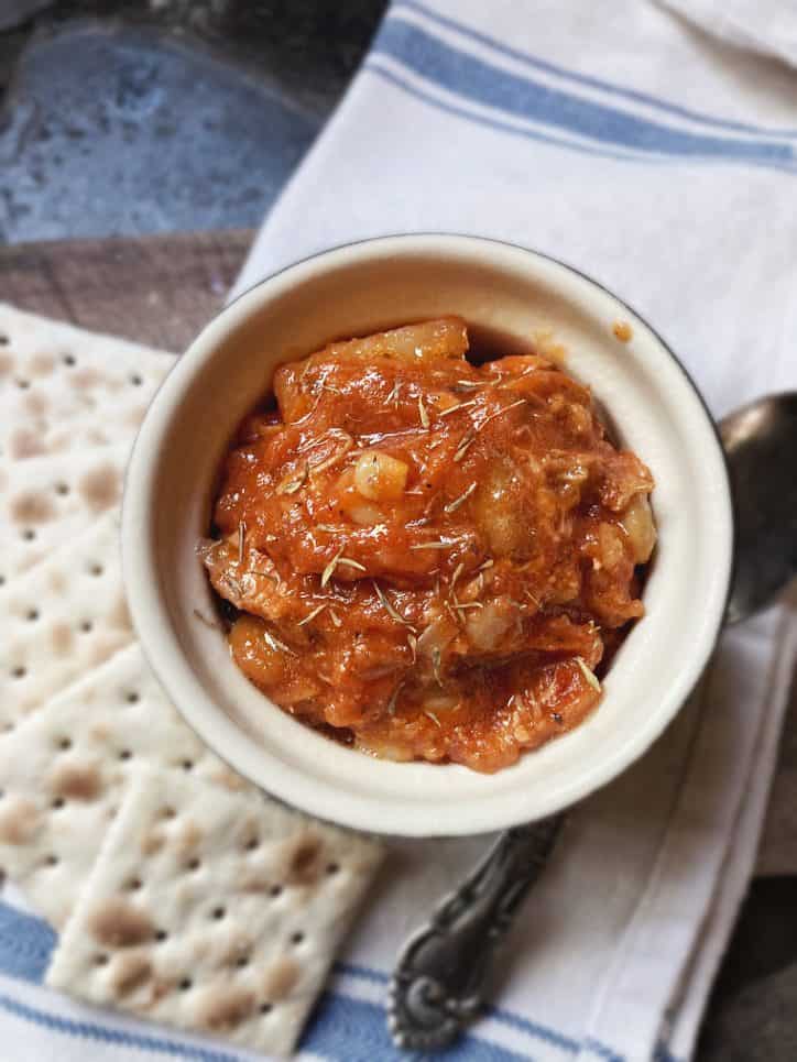 white bowl of North Carolina Brunswick Stew Recipe with crackers, spoon and napkin