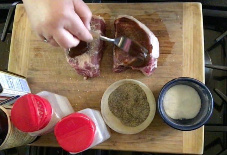 hand plunging fork into steaks