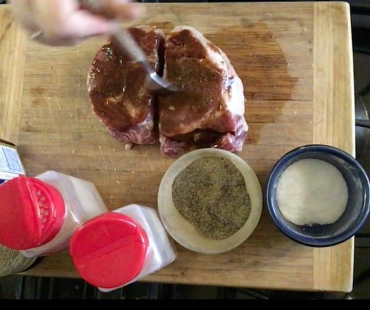 hand spreading A1 sauce over steak with fork