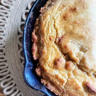 cast iron skillet with edges of crispy cornbread showing