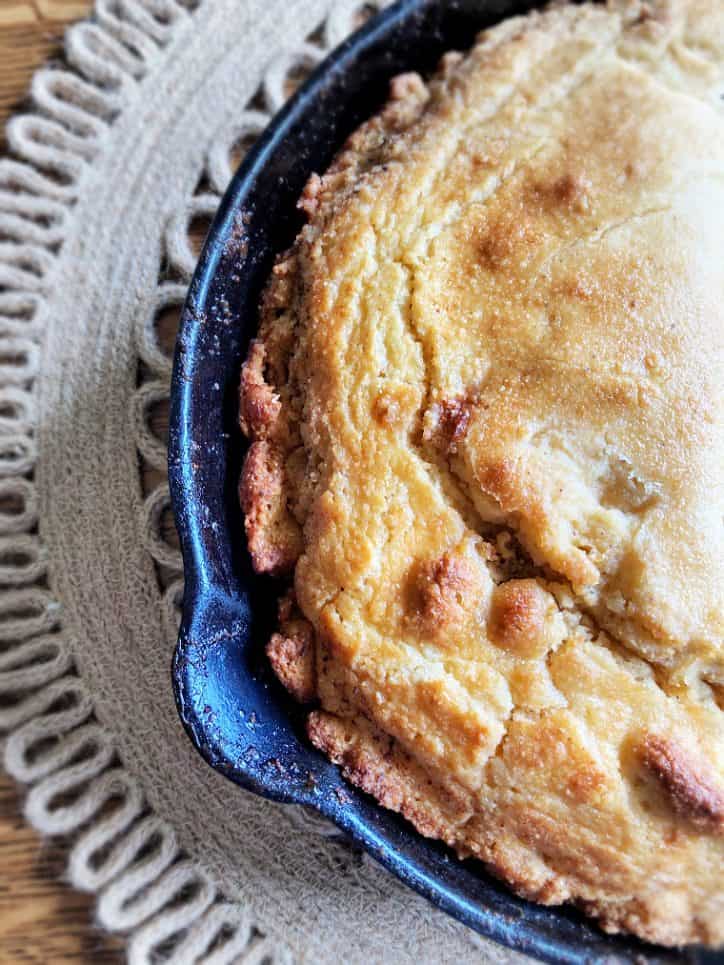 cast iron skillet with edges of crispy cornbread showing